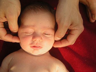 Hoe wordt baby massage te gebruiken om reflux te verlichten. Plaats uw baby op de vloer.